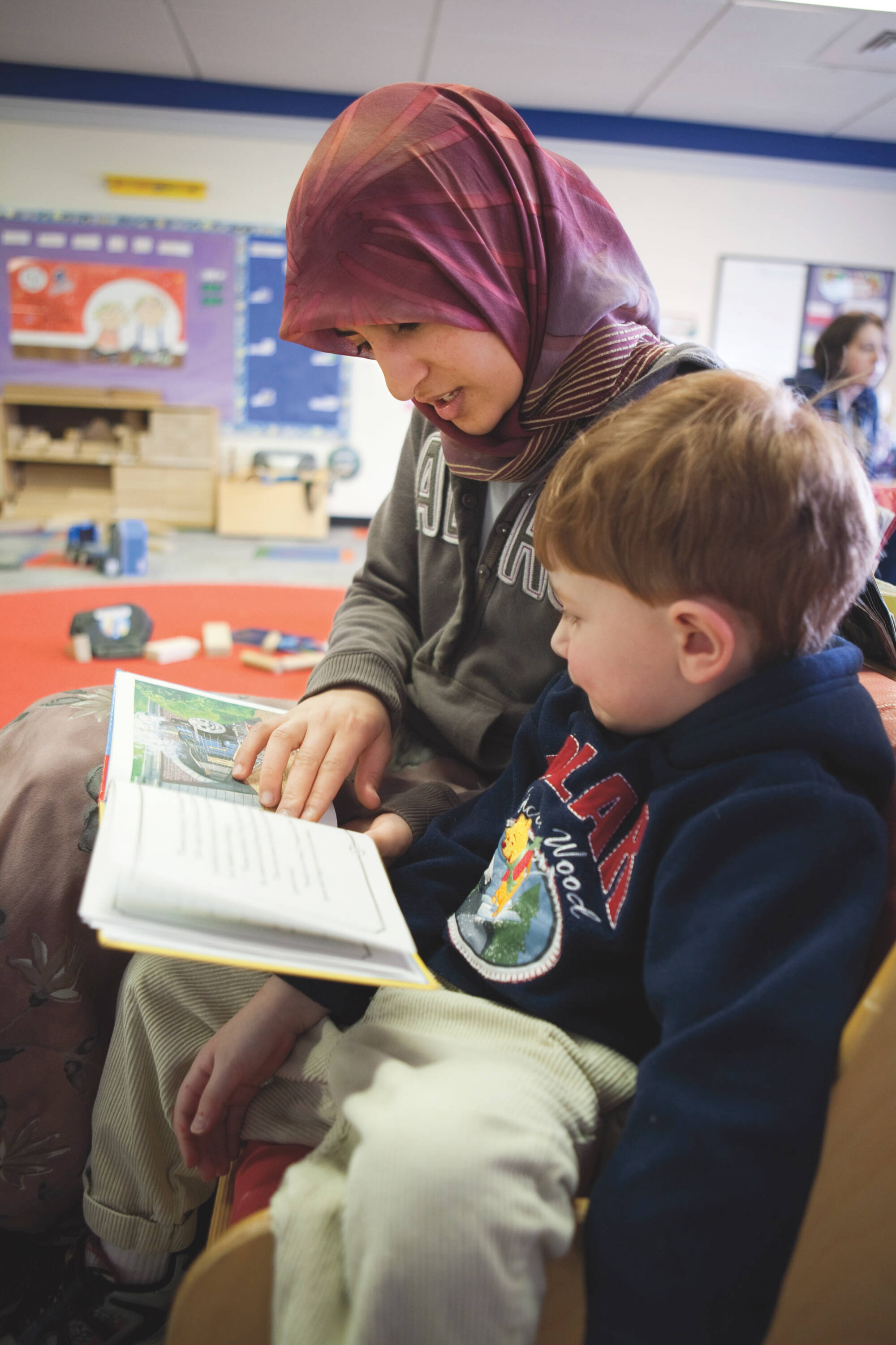 woman reading story to child sitting on her lap